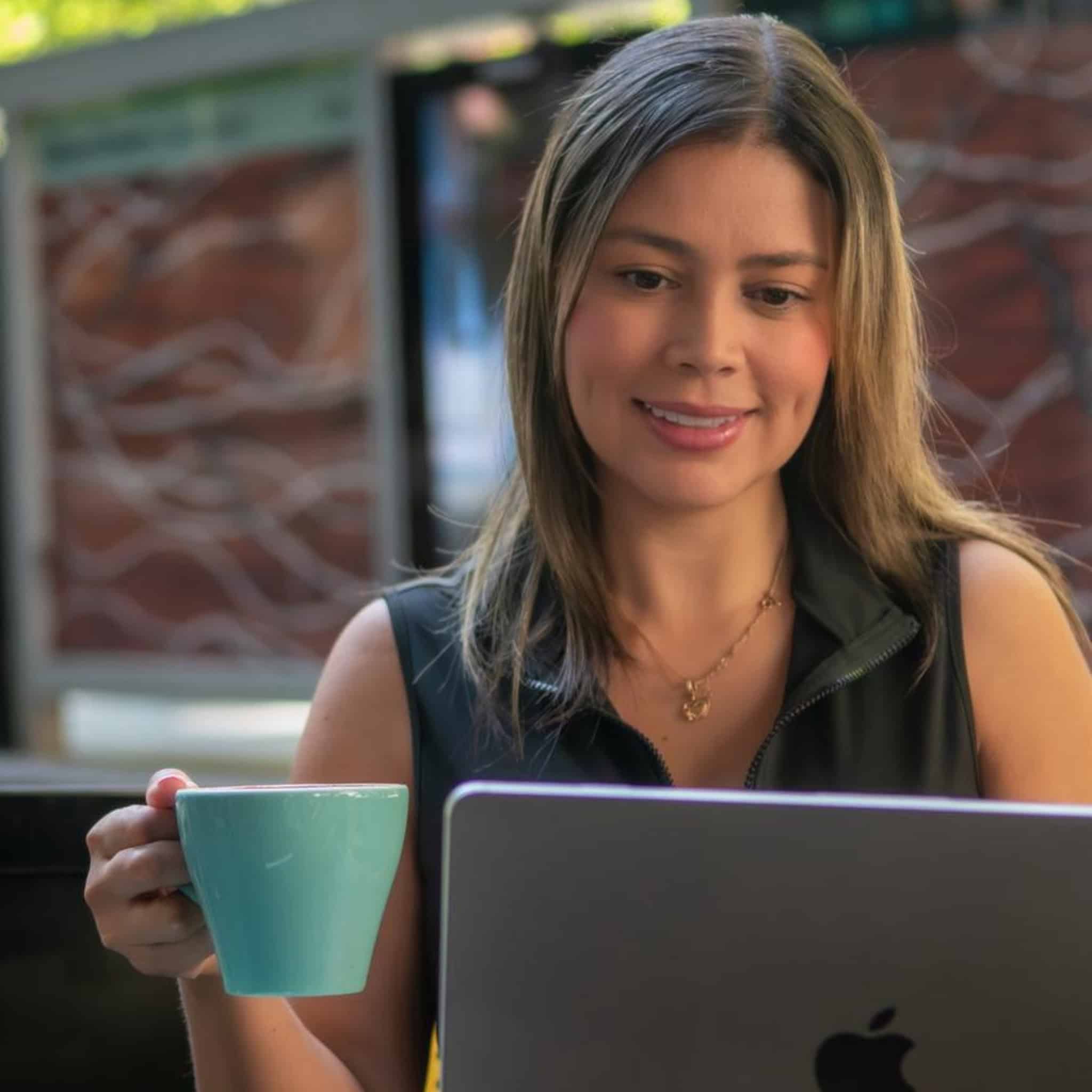 Cristina Carvajal trabajando en su oficina con taza de café.