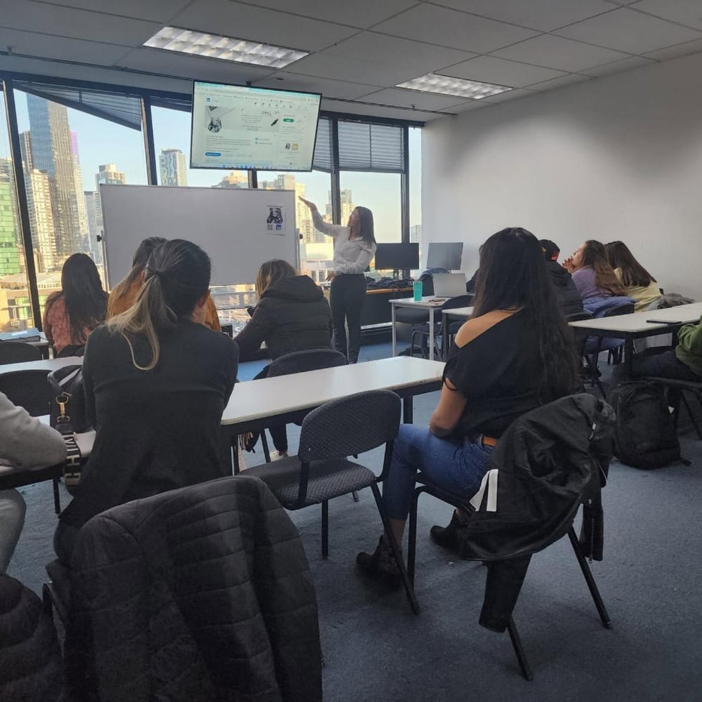 Cristina Carvajal, formación en aula con estudiantes y profesora en ciudad moderna.