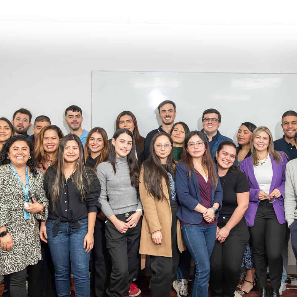 Liderazgo y trabajo en equipo en grupo diverso, con personas sonriendo y colaborando en un entorno p.